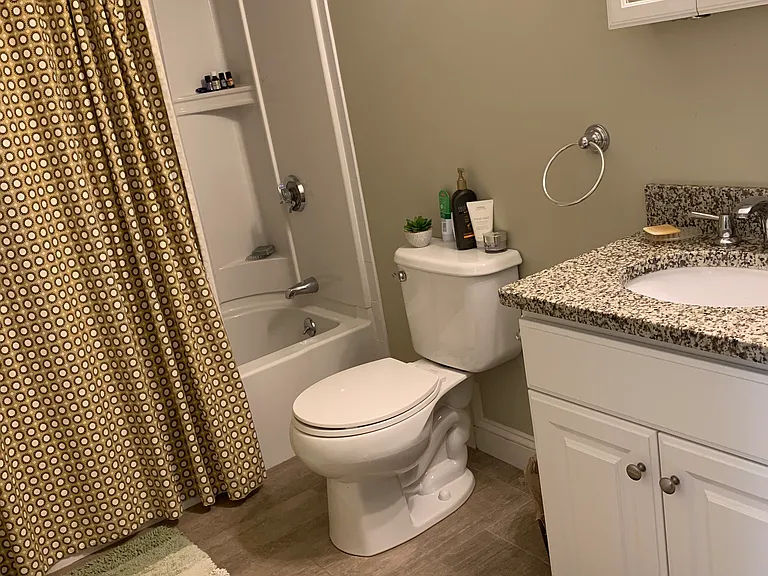 Bathroom features tile floor and granite countertop and full tub/shower.