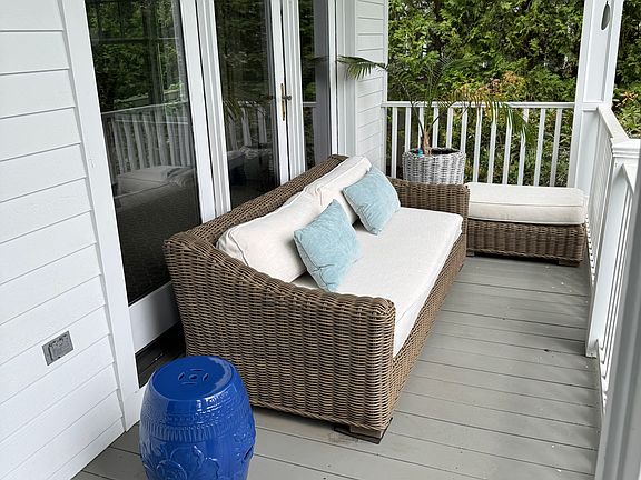Front porch with sofa and bench overlooking private, quiet court