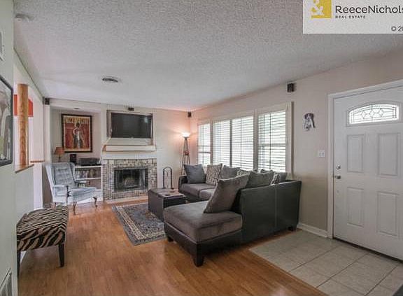Large living room with fireplace & tile entry.