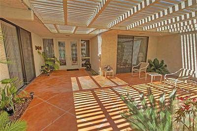 Gated, covered courtyard entry.   Newer double front doors with glass inserts.