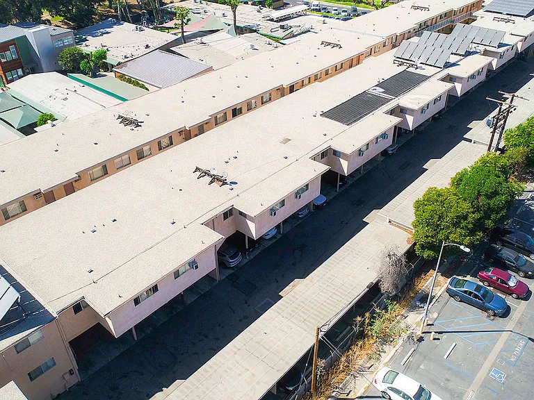Aerial drone photo of Woodbridge Park Apartments, showing white solar roofs and Solar Panels.