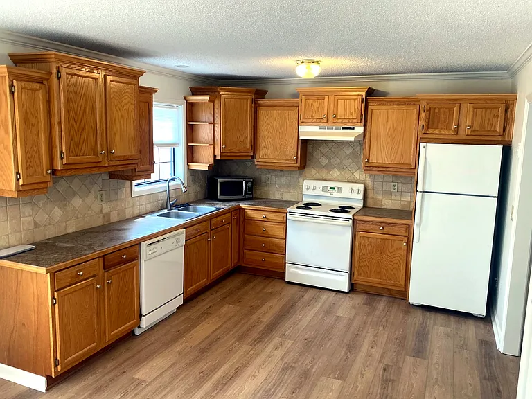 The kitchen boasts loads of storage and countertop prep space. Wood floors make for simple clean up.