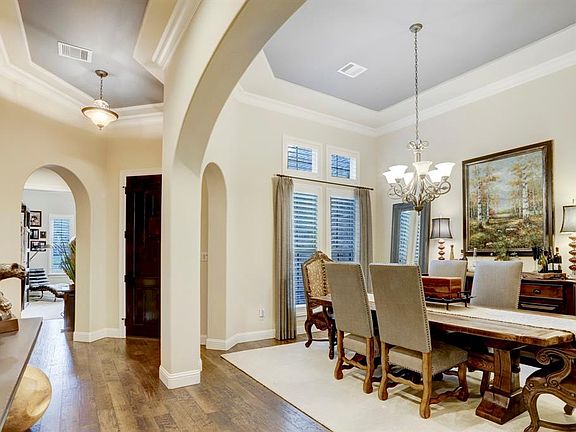 Looking back at front entry and view of formal dining room. High ceilings, archways, crown moulding and wood flooring give this home an elegant and welcoming feel.