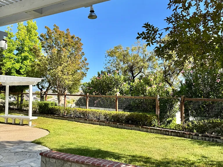 Fenced backyard, landscaped, green space and walkways, with no back neighbors