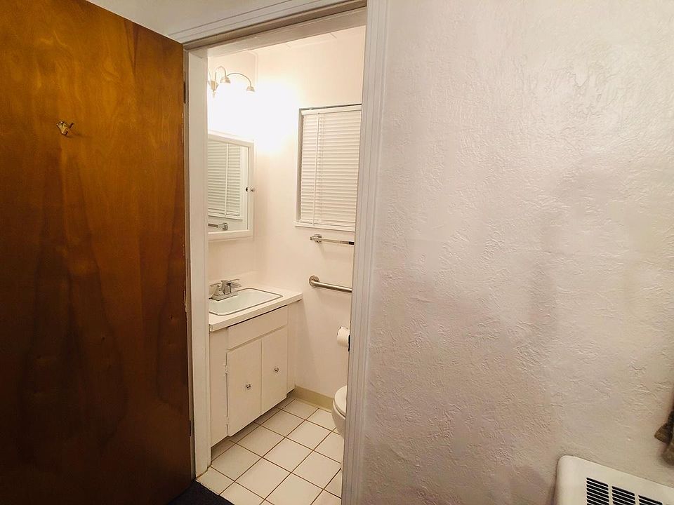 Half bathroom viewed from the front bedroom with the wood door open.
