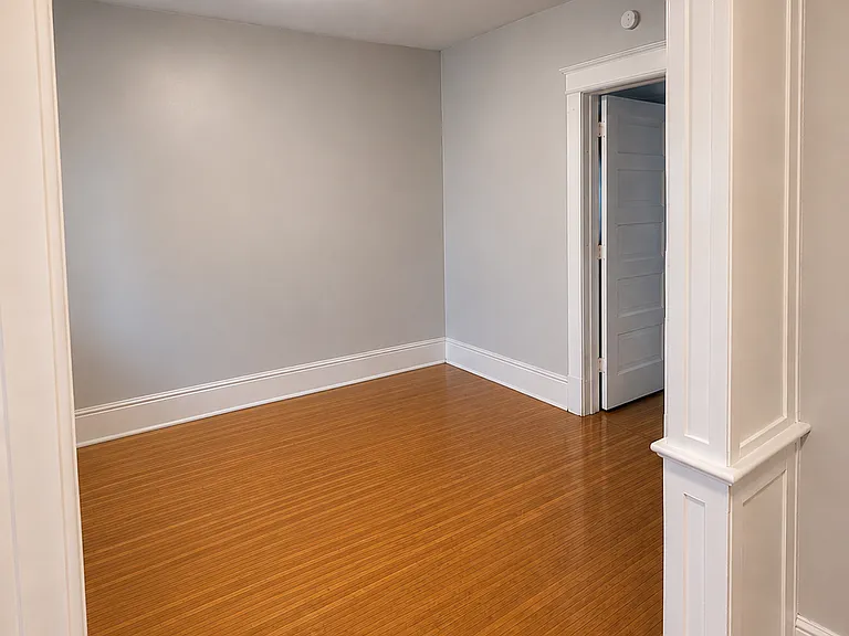 Standing back in entry way, front door behind you, facing left into living room. The open door you see is the bedroom.