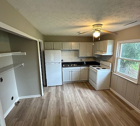 Kitchen with new flooring and countertops. All new paint throughout. Hook up for washer and dryer in "closet" area to the left.