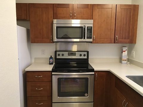 Updated kitchen with flattop electric stove/oven, microwave, refrigerator, updated kitchen cabinets and countertop