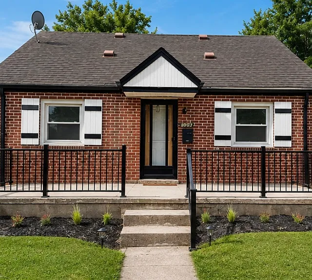 Charming brick home with updated black-and-white exterior accents and welcoming front porch.