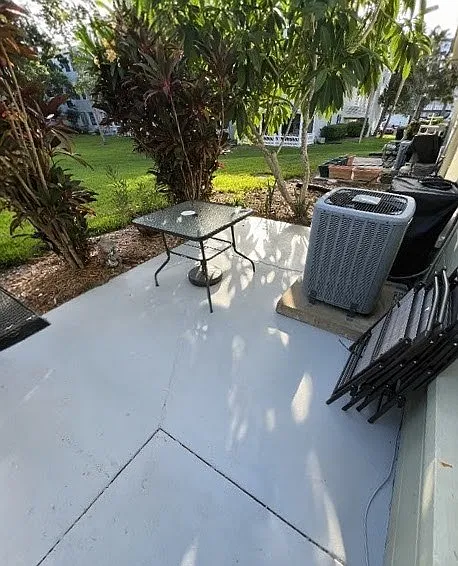 Refreshed back patio with table, chairs, and umbrella