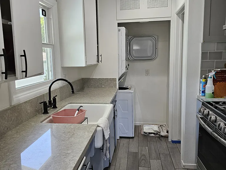 Kitchen: sink, window over sink, countertop, and laundry closet at top of photo.