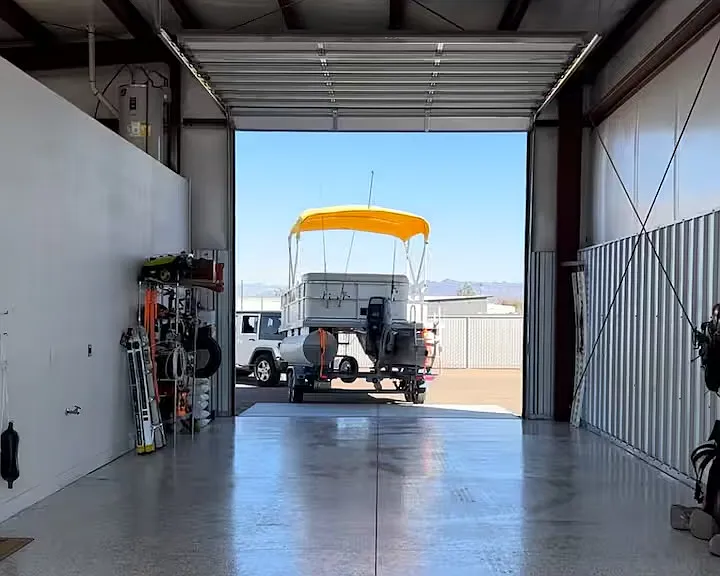 Oversized drive-through shop/garage with tall roll-up doors and room for boat, trailer, golf cart, or secure storage.