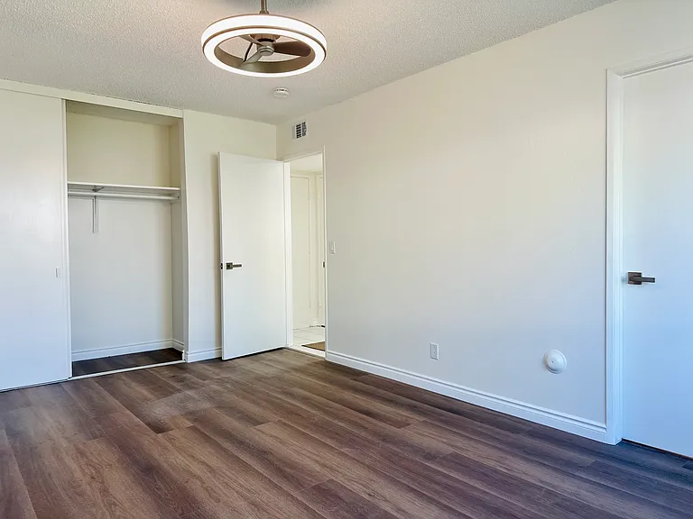 Primary suite bedroom on first floor, with new flooring, modern ceiling fan