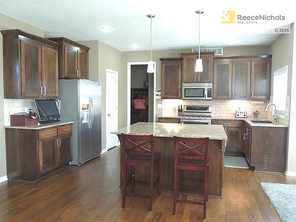 You will love this Custom Kitchen with Maple Cabinets, under cabinet lighting, european tile backsplash, granite, oversized island, pendant lighting, farm sink, nickel hardware, upgraded Kitchenaide stainless steel appliances, walk-in pantry and 3" dark h