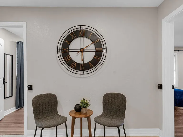 Welcoming shared seating nook with tile flooring, accent wall decor, and easy access to nearby rooms.