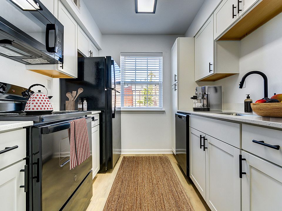 A newly renovated kitchen with white cabinetry, black appliances, and black finishes is shown at ReNew on Cantrell.