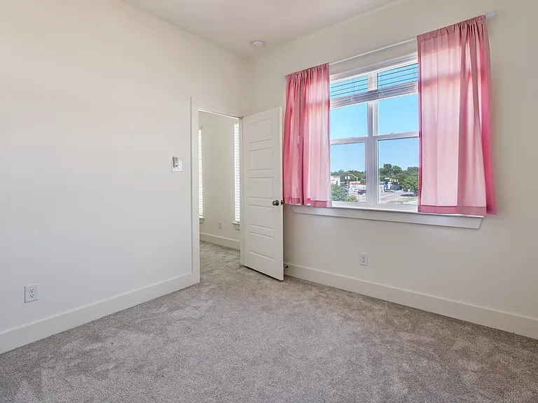 Bedroom #2 with lots of natural sunlight (drapes have been removed!).