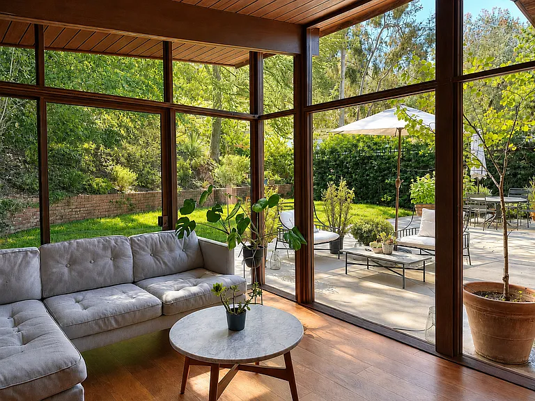 Glass-wrapped sunroom overlooking the backyard and patio. Can be used as bedroom or TV room _ A. Quincy Jones, 1951
