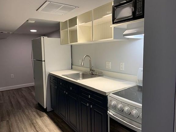 Full kitchen. Full size fridge, stove/oven, stove fan, microwave. Plenty of cabinets and open shelving.