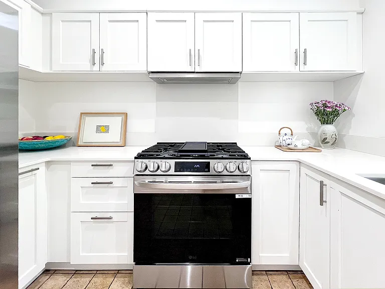 Fully renovated kitchen with brand-new quartz countertops and new premium appliances, including a high-end LG gas stove and Samsung appliances.