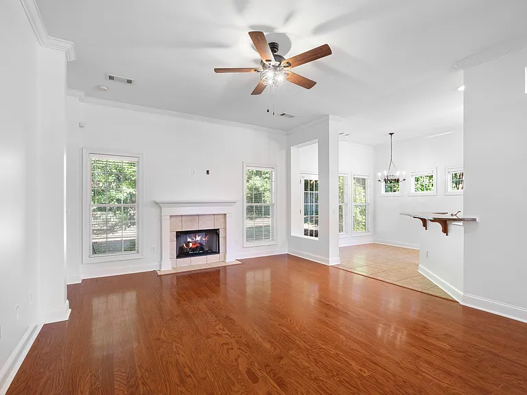 The great living room features a gas fireplace and wood flooring, along with fresh paint and wood floors.