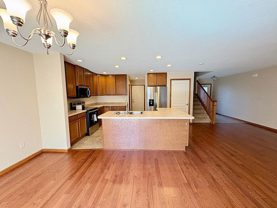 Spacious open concept living area showing front door entry way, stairs to the next floor, entry stairway to the basement. 

This also shows the hallway leading to the indoor garage space, walk in pantry and half bathroom.