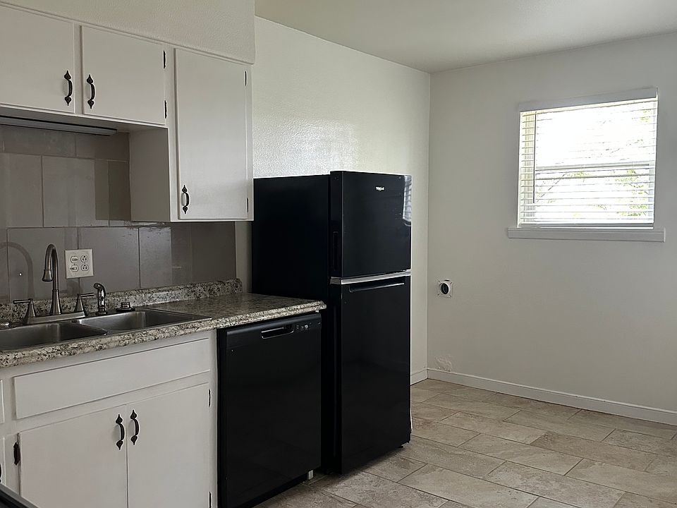 Freshly painted kitchen with black appliances.