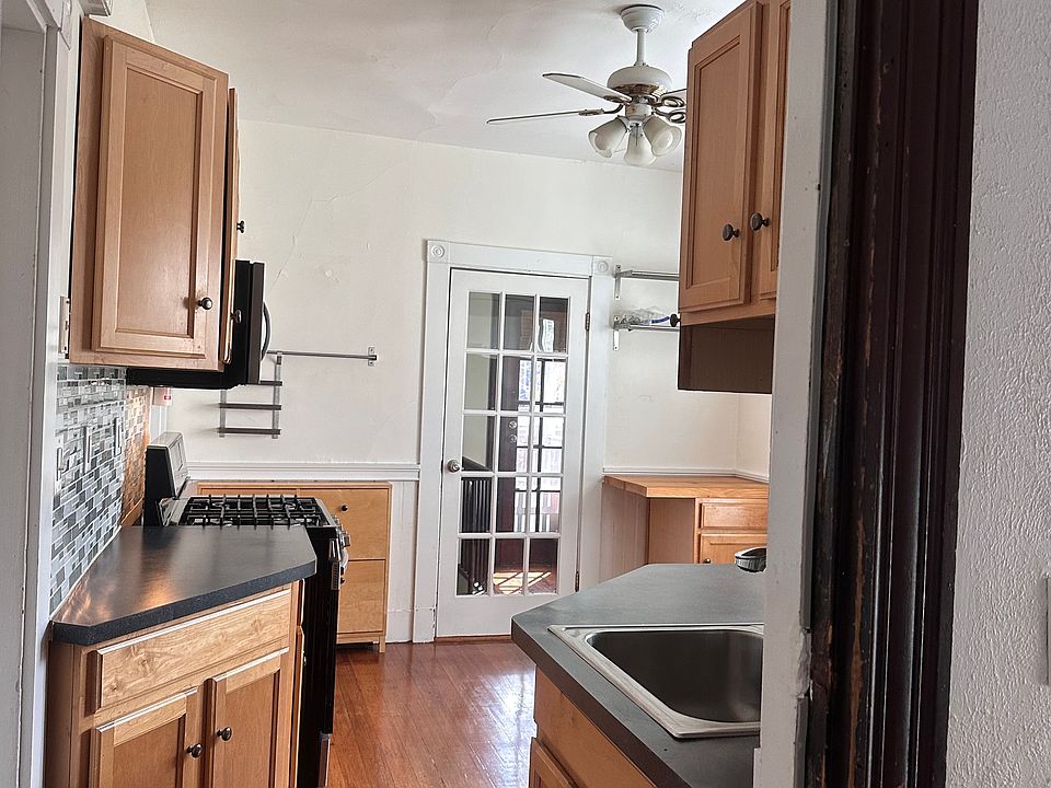 Looking into the kitchen from the front hallway. The glass door leads to a private back hallway and out to the porch.