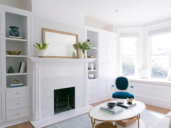 Recently updated original fireplace surrounded by custom built-ins in light, airy front bedroom