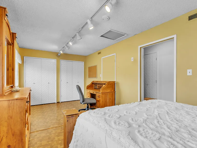 Bedroom facing the front yard. King size bed with one night stand, full dresser and two small closets. has a desk and a chair for homework and/or work. a extra large bedroom.