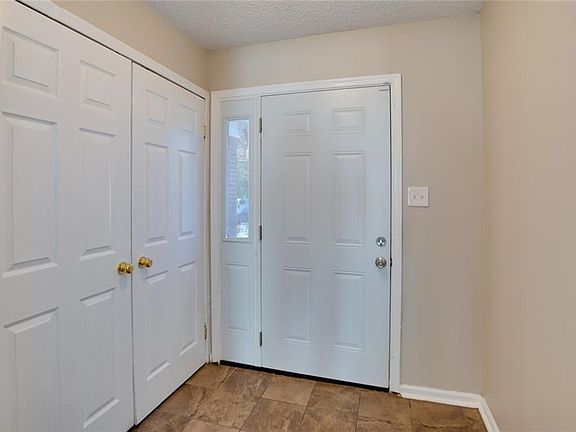 Open Foyer area with tile-Utility closet nearby