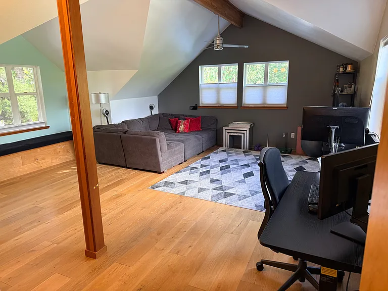 Very large media room with study area, television, large sofa, peloton