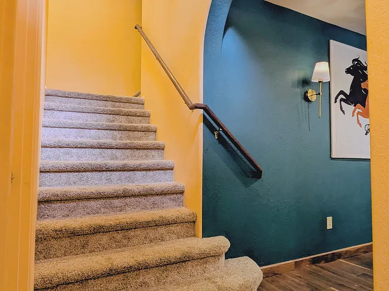 Stairs leading from front entry (with show and coat storage) up to 2 large bedroom suites