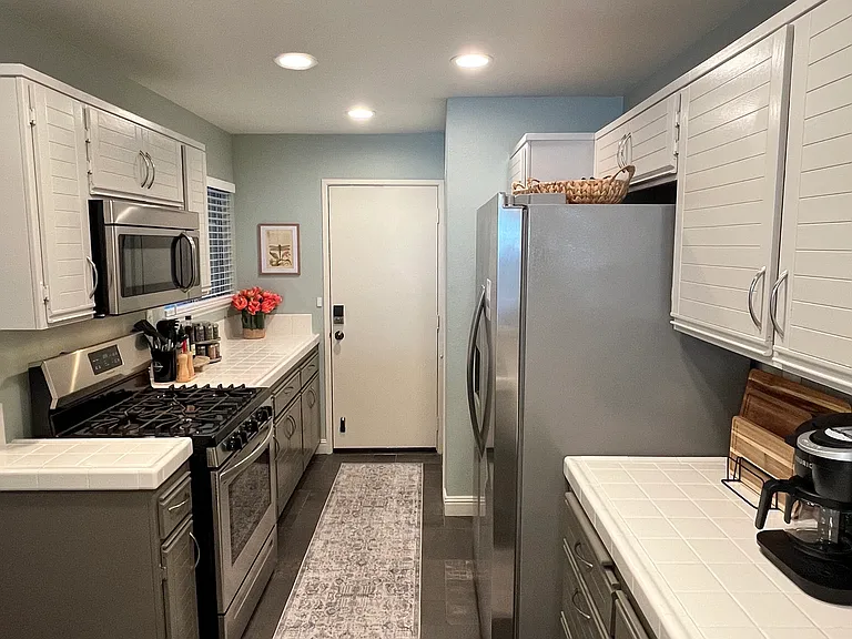 Spacious, fully equipped kitchen with direct access to the attached garage and additional covered parking conveniently located across from the garage.