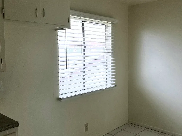 Dining area next to the kitchen with faux wood blinds installed