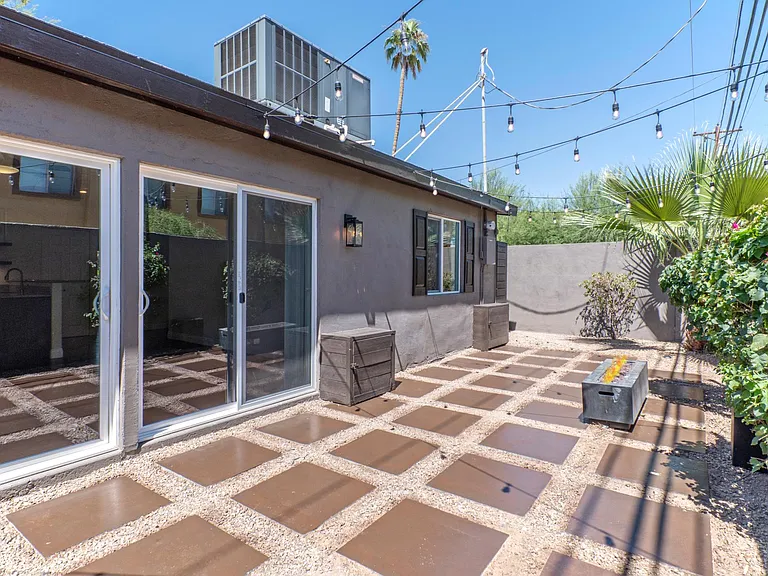 Custom poured concrete squares, bistro lights, and private firepit.