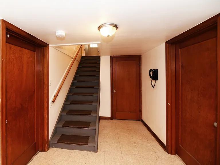 Unit B stairway and foyer area to back entry. 2 doors left and right to bedrooms. Middle door to kitchen and full bath