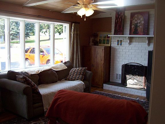 Living room with vaulted ceilings, fireplace, skylights, bow window