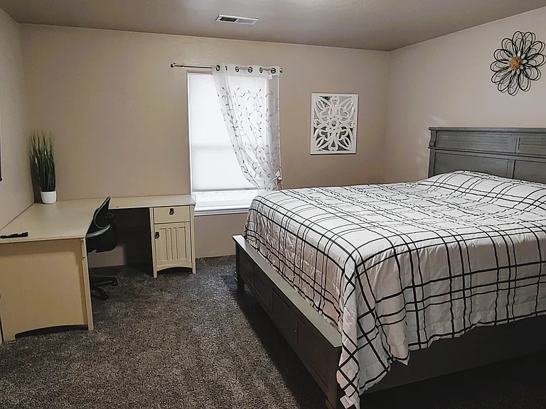 Master bed with corner desk, smart TV.