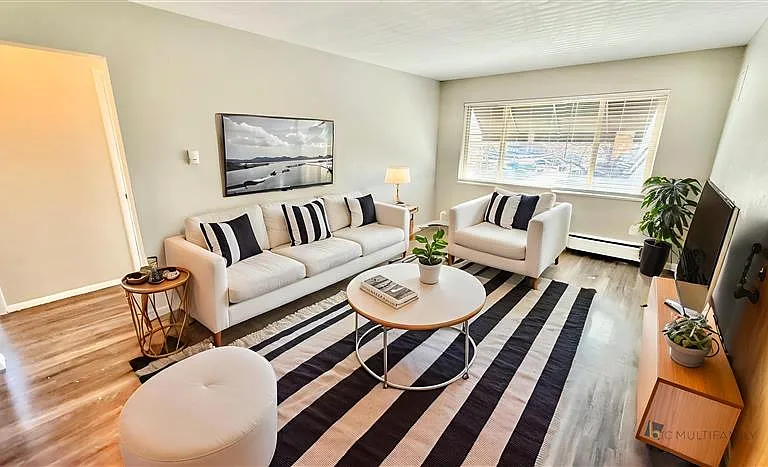 Inviting living room with sleek modern furniture, natural light, and stylish decor, perfect for relaxation and entertainment.
