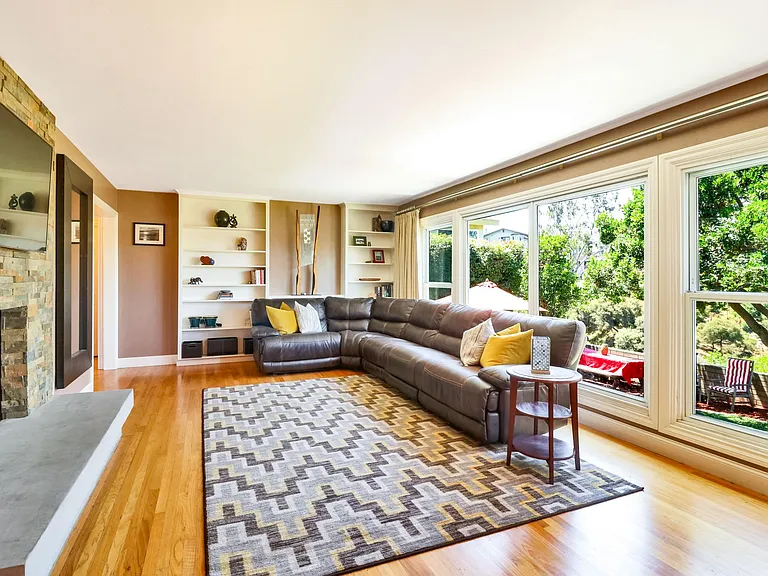 Living room has gorgeous views of the backyard and canyon. Fireplace was recently remodeled to create a more natural and modern look in the space (56' LED TV included) . Ample storage in built in bookcases.
