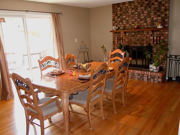 Hardwood Floor and Brick Fireplace Accent the Dining Room.