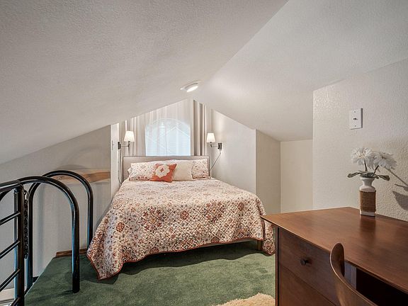 Upper loft area with queen bed and desk.