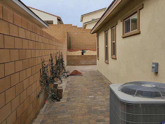 side yard with pavers and jasmine vines