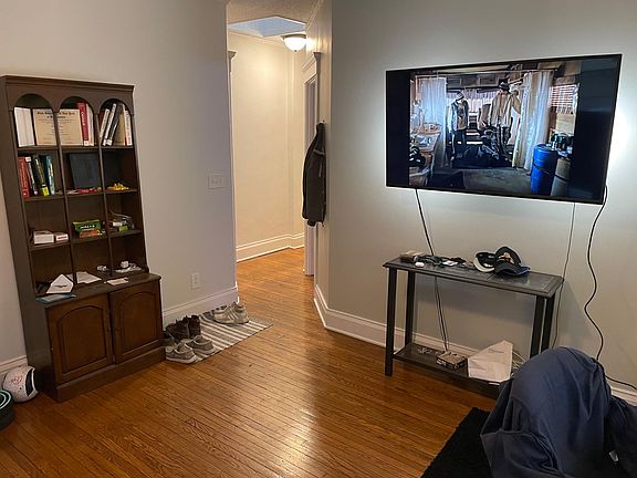 Living room with outgoing tenant's furniture looking toward hallway