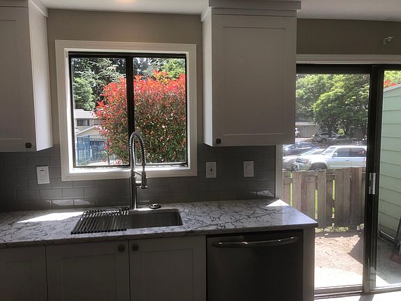 Kitchen with view of back patio. Room for table to right of photo. Gate leads to adjacent community pool. (currently not open due to COVID)