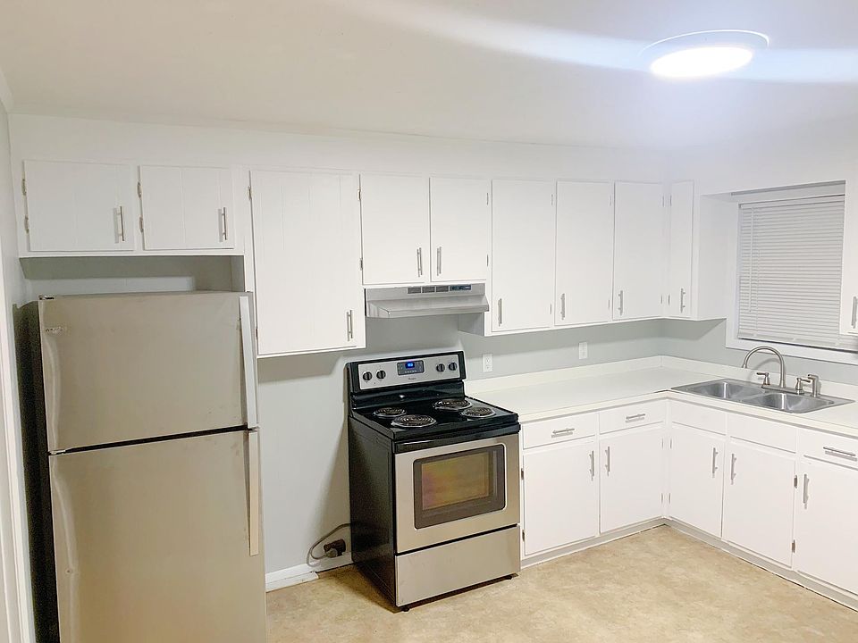 Kitchen with refinished cabinets and new stainless steel appliances. Window looks onto back porch and large backyard surrounded by woods.