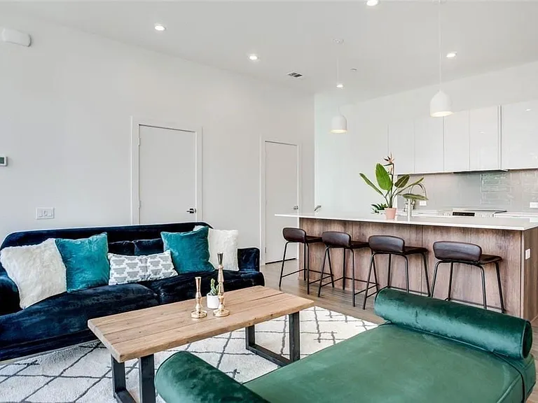 Open-concept living area featuring recessed lighting, light wood-finish flooring, and a kitchen island with seating