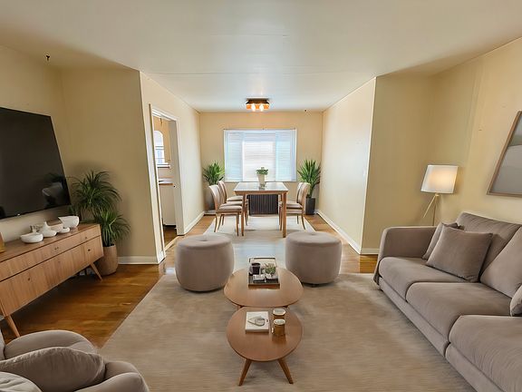 Charming living and dining area featuring plush sofas, modern decor, and abundant natural light from wide windows. Charming living and dining area featuring plush sofas, modern decor, and abundant natural light from wide windows.
