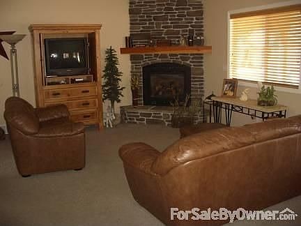 Living room with rock fireplace
						:
						The natural gas fireplace puts out plenty of heat. Very comfortable